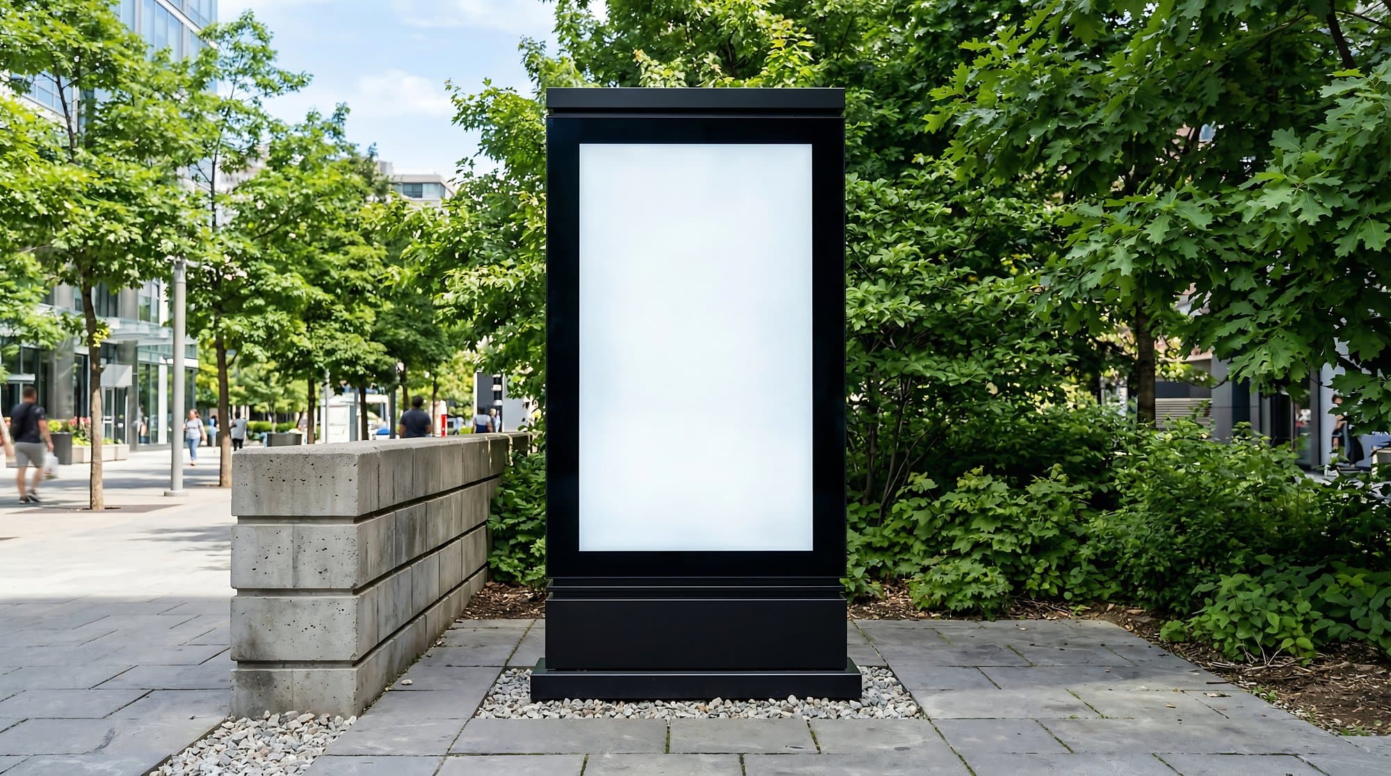 Czarny totem z jasną powierzchnią ekspozycji w otoczeniu zieleni